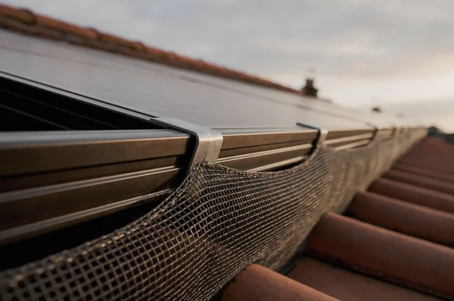 Close-up of clip-on steel mesh sealing the edge of a rooftop solar panel, the leading bird control solar panel proofing method for pitched roofs